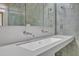 Sleek bathroom featuring double sinks, modern faucets, a large mirror, and green accent tiles for a clean, contemporary look at 206 Spring Ln, Chapel Hill, NC 27514