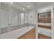 Well-lit bathroom featuring a wooden vanity, modern mirror, and a view of a tiled shower/tub, for a serene bathing experience at 206 Spring Ln, Chapel Hill, NC 27514