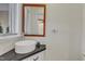 Powder room featuring floating vessel sink, granite countertop, and framed mirror at 206 Spring Ln, Chapel Hill, NC 27514