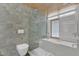 Tiled bathroom with a shower and deep soaking tub under a window at 206 Spring Ln, Chapel Hill, NC 27514