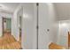 Hallway featuring hardwood floors, white walls, and doorways leading to other rooms in the home at 206 Spring Ln, Chapel Hill, NC 27514