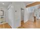 Hallway features wood floors, bright white walls, stairs to the upper level, and an entryway to the bath at 206 Spring Ln, Chapel Hill, NC 27514