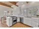 Bright kitchen featuring wood beam ceiling, stainless steel appliances, and white cabinetry with tile flooring at 206 Spring Ln, Chapel Hill, NC 27514