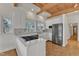 Bright kitchen features a wood beam ceiling, stainless steel appliances, and white cabinets with tile flooring at 206 Spring Ln, Chapel Hill, NC 27514