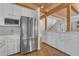 Bright kitchen features wood beam ceiling, stainless steel appliances, white cabinetry and open floorplan into the living space at 206 Spring Ln, Chapel Hill, NC 27514