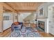 Comfortable living room featuring hardwood floors, fireplace, wooden ceiling beams, and natural light at 206 Spring Ln, Chapel Hill, NC 27514