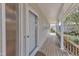 Cozy covered porch with wood flooring, offering a relaxing outdoor space and a view of the garden at 206 Spring Ln, Chapel Hill, NC 27514