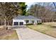 Beautiful home with a long driveway leading to a two-car garage and a covered front porch at 208 Hunting Lodge Rd, Clayton, NC 27520