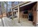 Under-deck patio with full outdoor kitchen, bar, and lounge seating, perfect for entertaining at 208 Hunting Lodge Rd, Clayton, NC 27520