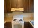 Kitchen featuring wooden cabinets, a white oven, and light colored countertops at 228 Adams St, Cary, NC 27513