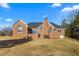 Home's backyard featuring the house's brick exterior, with a patio and chimney at 2318 Rogers Rd, Graham, NC 27253