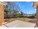 Spacious back patio features a brick border and metal railing with a clear view of trees and sky at 2318 Rogers Rd, Graham, NC 27253