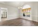 Formal dining room with hardwood floors, a chandelier and arched window with ornate curtains at 2318 Rogers Rd, Graham, NC 27253