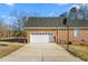 Garage and driveway with a basketball hoop above the brick siding at 2318 Rogers Rd, Graham, NC 27253