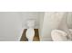 This is a half bathroom with hardwood flooring, a white toilet and pedestal sink at 25 Scotch Bonnet Rdg, Clayton, NC 27520