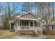 Charming home with a covered porch, brick foundation, and mature landscaping at 2513 Drexall Ave, Durham, NC 27704