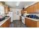 Well-lit kitchen featuring wooden cabinets, white appliances, and patterned flooring at 2513 Drexall Ave, Durham, NC 27704