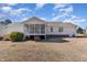 Home's backyard features a screened porch and classic exterior under a beautiful blue, cloudy sky at 254 Pedernales Dr, Smithfield, NC 27577