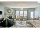 Well-lit living room featuring a fireplace, large windows, hardwood floors, and stylish decor at 304 Presenteer Trl, Apex, NC 27539