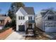 New construction two-story home with a brick front porch, black trimmed windows, and an attached garage at 304 Shepherd St, Raleigh, NC 27607