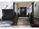 Inviting front entrance with brick stairs, dark trim, and decorative shrubbery at 304 Shepherd St, Raleigh, NC 27607