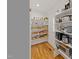 Organized pantry with wooden floor and white shelving stocked with wicker baskets and containers at 304 Shepherd St, Raleigh, NC 27607