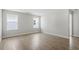 A spacious bedroom featuring hardwood flooring, two windows, and fresh paint at 319 N Maple Walk # 213, Garner, NC 27529