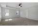 This bedroom has carpet, a ceiling fan, tray ceiling, and large windows with views of the community at 319 N Maple Walk # 213, Garner, NC 27529