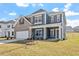 Charming two-story home with blue siding, brick accents, and a well-manicured lawn on a sunny day at 319 N Maple Walk # 213, Garner, NC 27529