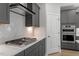 This kitchen features gray cabinets, stainless steel appliances, quartz countertops and a tile backsplash at 319 N Maple Walk # 213, Garner, NC 27529