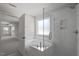 Bright bathroom with a glass-enclosed shower and separate soaking tub, and doorway to the bedroom at 322 N Maple Walk Walk # 237, Garner, NC 27529