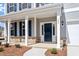 Inviting front porch with stone accents, white pillars, and a modern black front door at 322 N Maple Walk Walk # 237, Garner, NC 27529