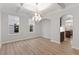 Dining area with wood floors and large windows, illuminated by a modern chandelier and an arched pass through at 347 N. Maple Walk Dr # 211, Garner, NC 27529