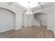 Spacious dining area featuring wood floors, a modern chandelier, and staircase access at 347 N. Maple Walk Dr # 211, Garner, NC 27529