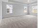 Large main bedroom with plush carpeting, tray ceiling, fan and ample natural light from several windows at 347 N. Maple Walk Dr # 211, Garner, NC 27529
