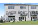 Rear exterior of townhomes featuring black balconies, a green lawn, and privacy fences at 4093 Elk Crk Ln, Raleigh, NC 27612