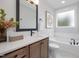 Bright bathroom featuring a soaking tub, framed art, and a light wood vanity with white countertop at 4095 Elk Crk Ln, Raleigh, NC 27612