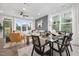 Open-concept dining room and living room with large windows, modern decor, and a stylish ceiling fan at 4095 Elk Crk Ln, Raleigh, NC 27612