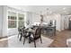 Open-concept living and dining area with barstool seating, modern lighting, and stainless steel appliances at 4095 Elk Crk Ln, Raleigh, NC 27612