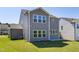 Expansive green backyard showcases a gray two-story home with large windows and a patio at 41 Silver Moon Ln # 115, Clayton, NC 27527