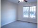 Bright bedroom featuring neutral carpet, a ceiling fan, and a large window offering natural light at 441 Hill Rd, Rougemont, NC 27572