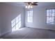 The bedroom has carpet, two windows, a ceiling fan, and lots of natural light at 441 Hill Rd, Rougemont, NC 27572
