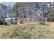 A fully fenced backyard with playset, storage shed, and mature trees at 457 Cokesbury Park Ln, Fuquay Varina, NC 27526