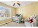 Bright bedroom with a crib, rocking chair, and a large window at 457 Cokesbury Park Ln, Fuquay Varina, NC 27526