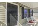 A cozy porch with a black door, accent lighting, and relaxing chairs. Perfect for enjoying peaceful mornings at 457 Cokesbury Park Ln, Fuquay Varina, NC 27526