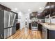 The kitchen area includes stainless steel appliances, dark wood cabinetry and wood flooring at 457 Cokesbury Park Ln, Fuquay Varina, NC 27526