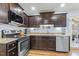 A well-equipped kitchen showcasing stainless steel appliances and sleek, dark cabinetry at 457 Cokesbury Park Ln, Fuquay Varina, NC 27526