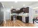 This kitchen features stainless steel appliances, dark wood cabinetry, and wood flooring at 457 Cokesbury Park Ln, Fuquay Varina, NC 27526