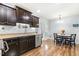 The kitchen shows dark wood cabinetry and stainless steel appliances beside a dining area at 457 Cokesbury Park Ln, Fuquay Varina, NC 27526