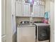 A dedicated laundry room with a washer, dryer, and overhead cabinets at 457 Cokesbury Park Ln, Fuquay Varina, NC 27526